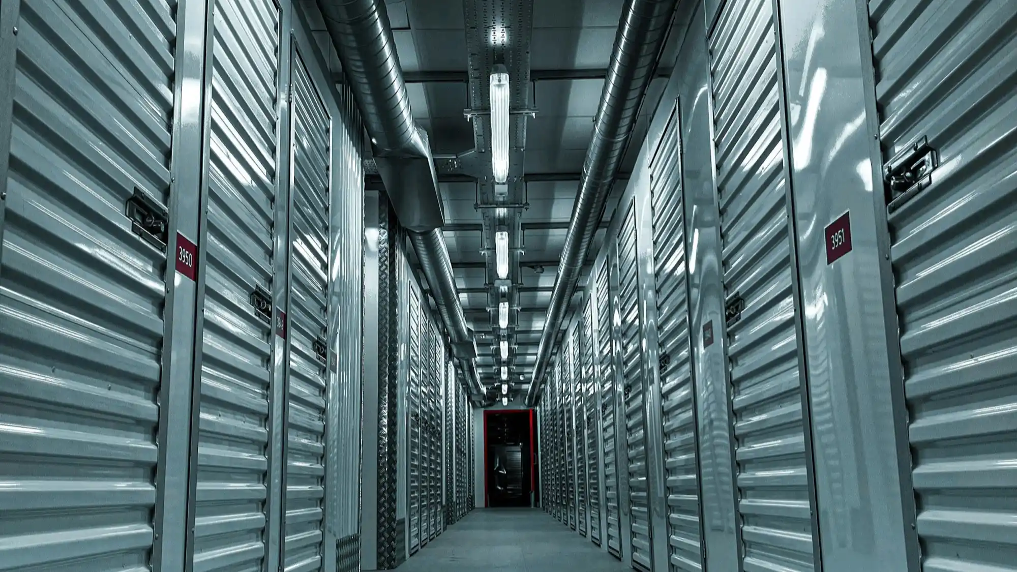 Wide bright corridor inside a self storage facility with rows of metal unit doors