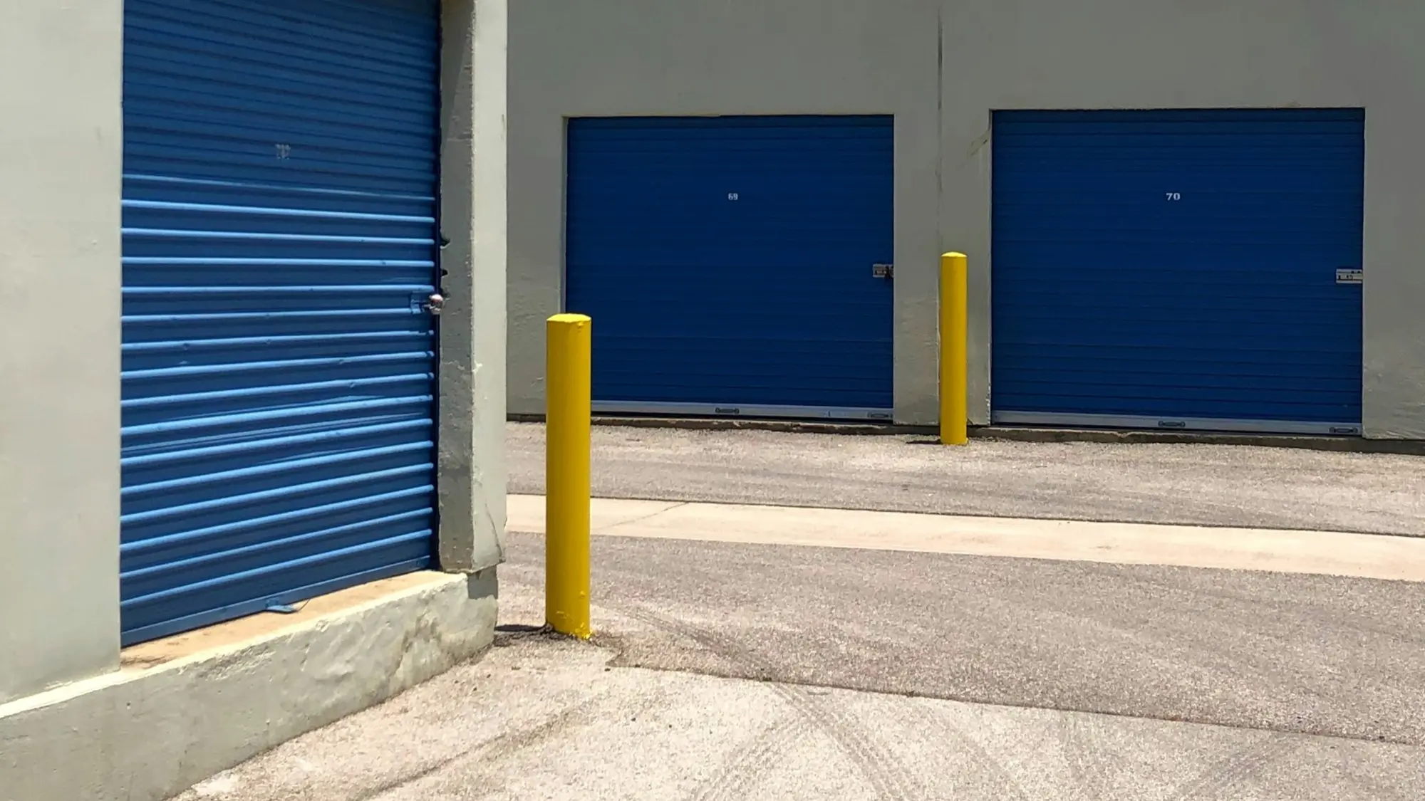Self storage facility with blue roll up doors under a clear blue sky