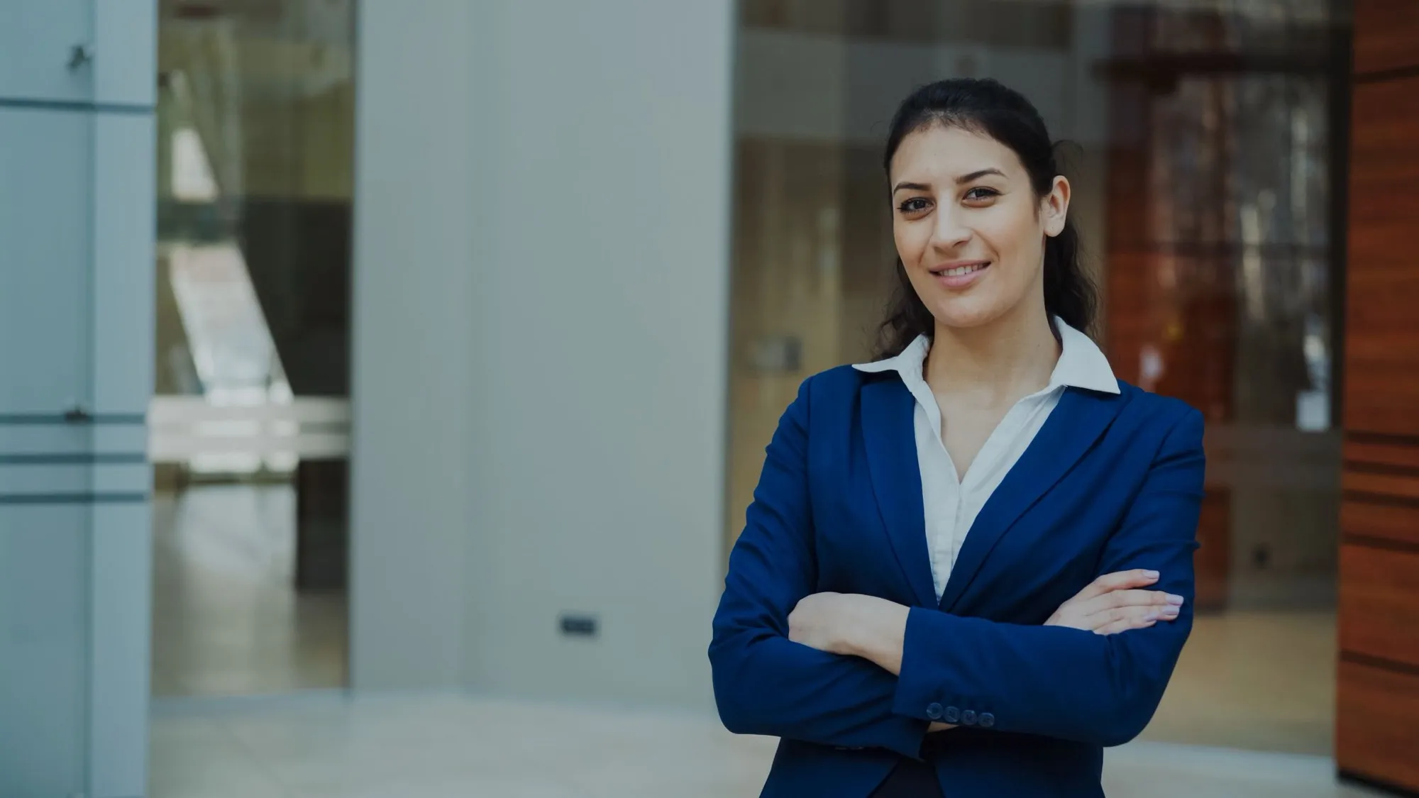 A confident self storage management professional in a blue suit in a modern office lobby