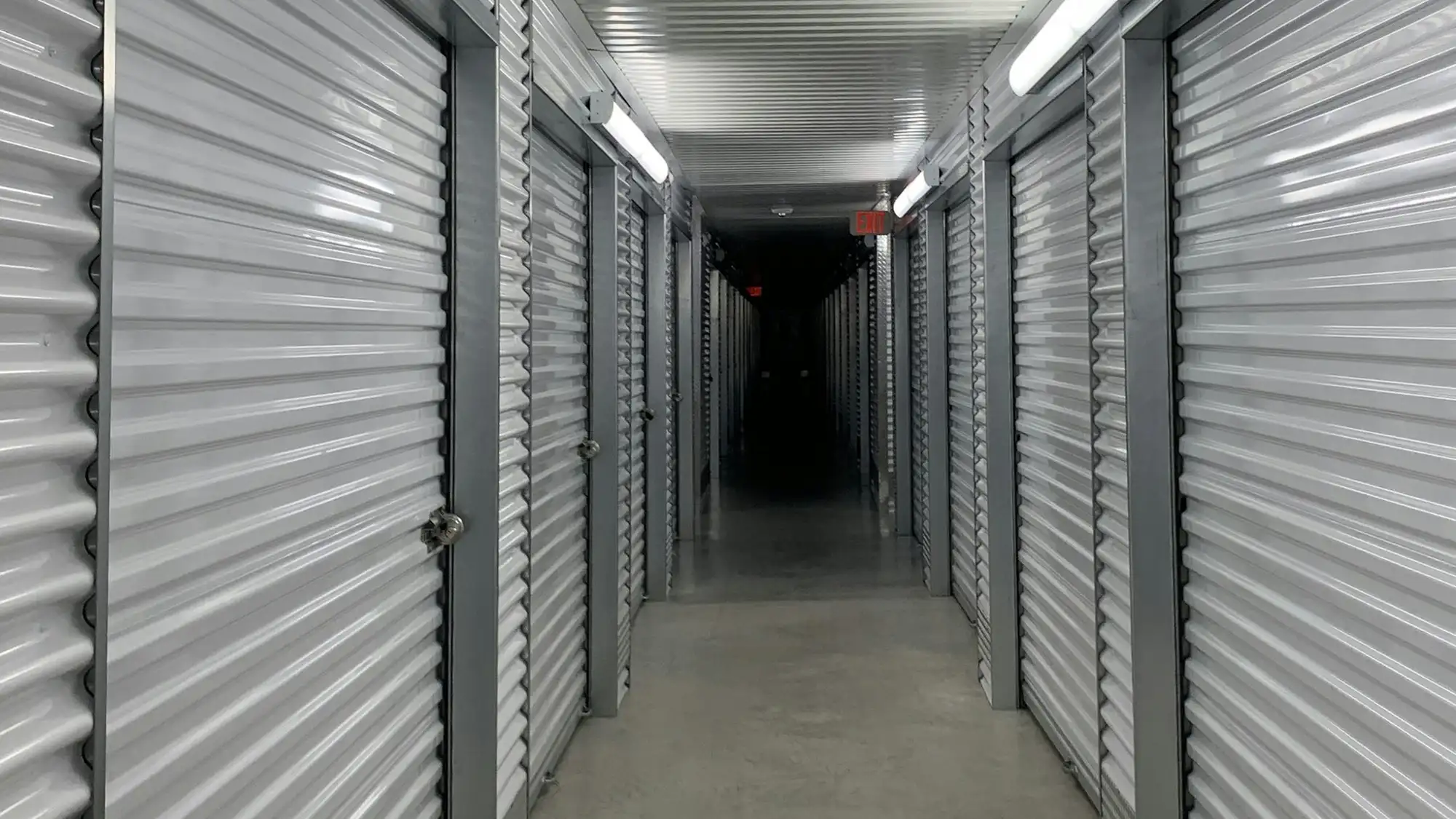Bright clean corridor of a self storage facility lined with metal unit doors