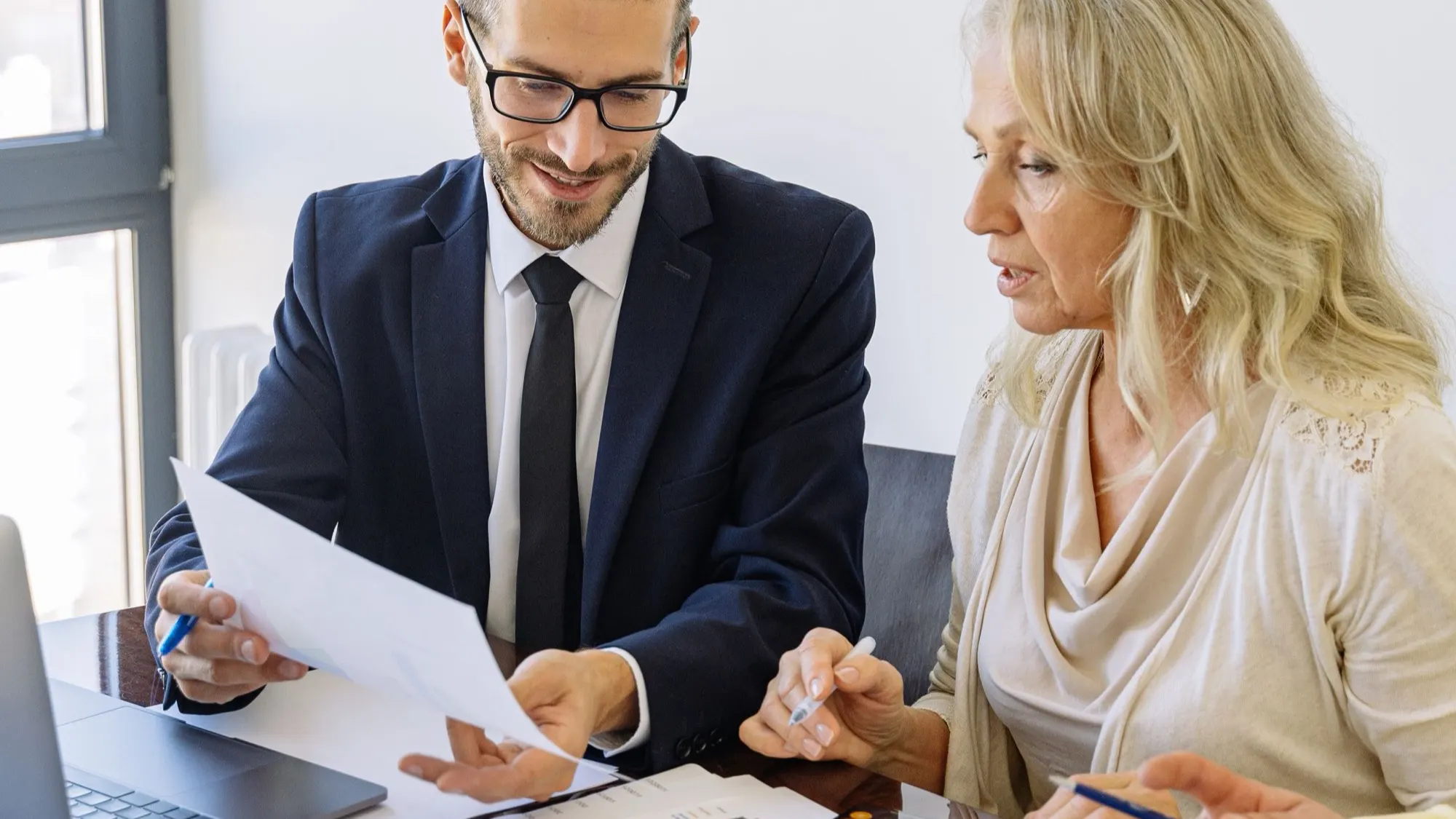 Two business professionals reviewing self storage investment plans at a desk